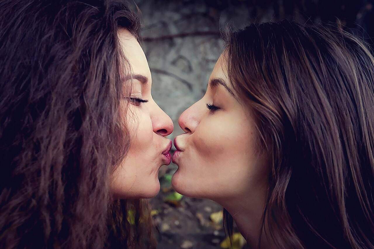 two women pecking on the lips